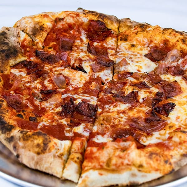 Close-up of a freshly baked pizza from The White Bull Tavern, topped with pepperoni and cheese.